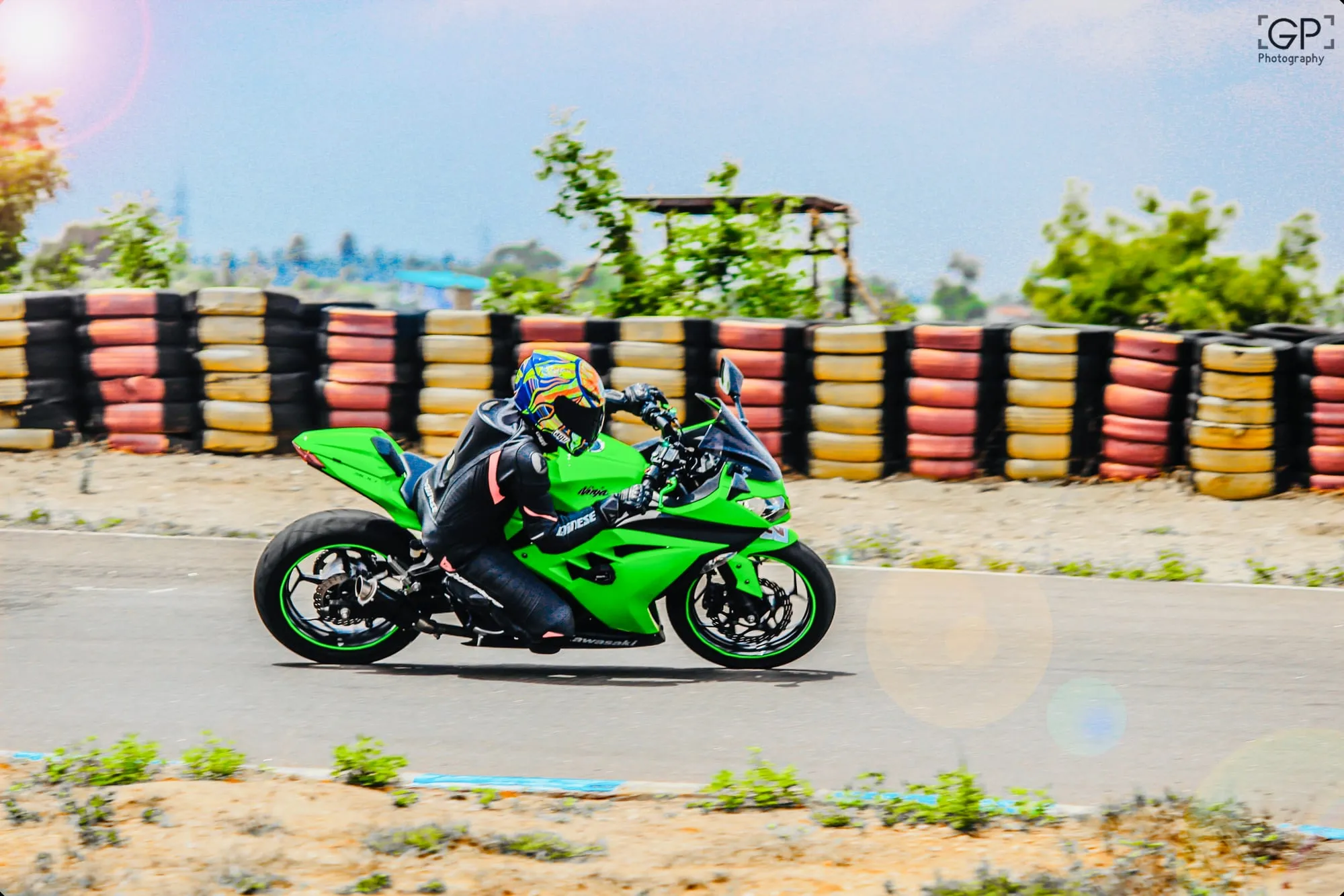 Leaning a green Kawasaki Ninja through a corner past the tyre wall